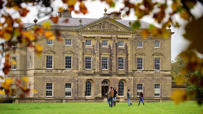 A family of four walking in the garden at Castle Ward, County Down, with the house in the background